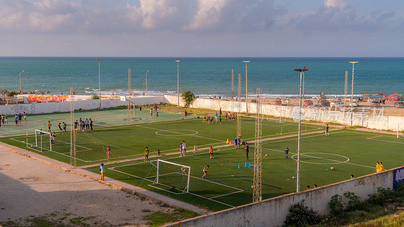 人们在海滩附近的突尼斯La Marsa踢足球。